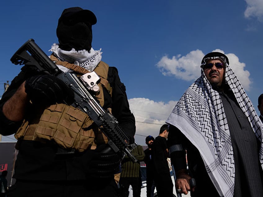 Members of an Iraqi Shiite militant group attend the funeral of a fighter with the Kataib Hezbollah, who was killed in a U.S. airstrike, in Baghdad, Iraq, Thursday, Jan. 25, 2024. (AP Photo/Hadi Mizban)