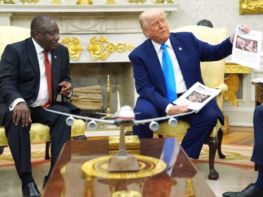 President Donald Trump shows documents as he meets South Africa's President Cyril Ram