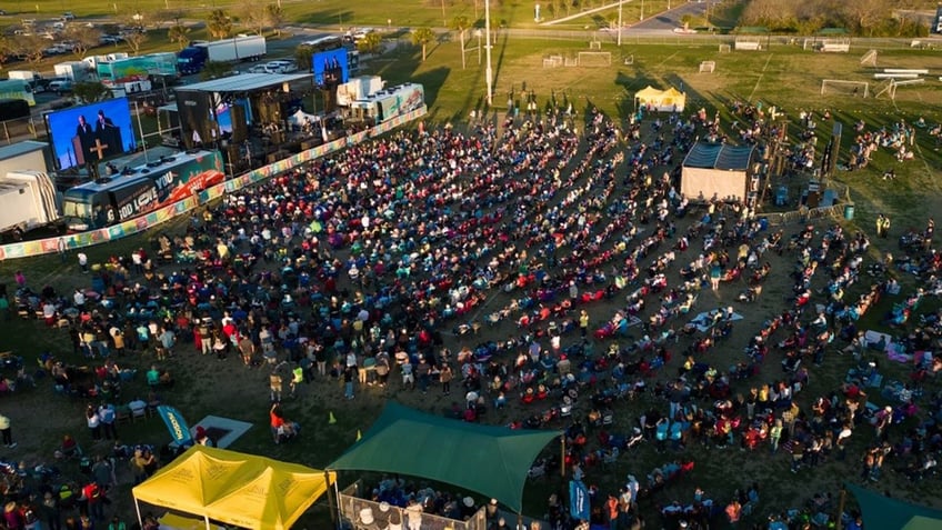 crowd of people in rows in front of screens