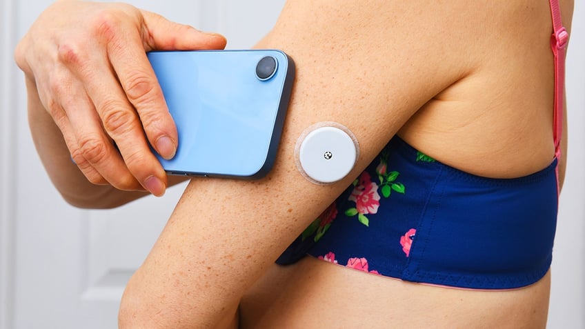 Diabetes monitoring device on woman's arm
