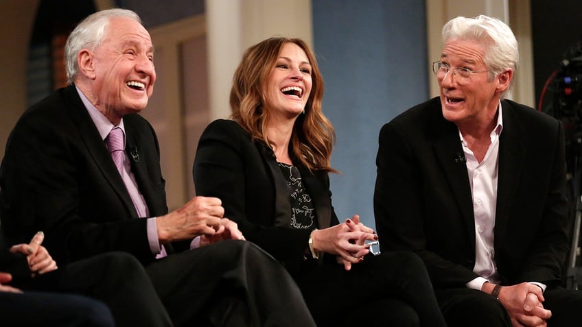 Garry Marshall in a black suit and purple tie laughs with Julia Roberts and Richard Gere, also in black on "TODAY"