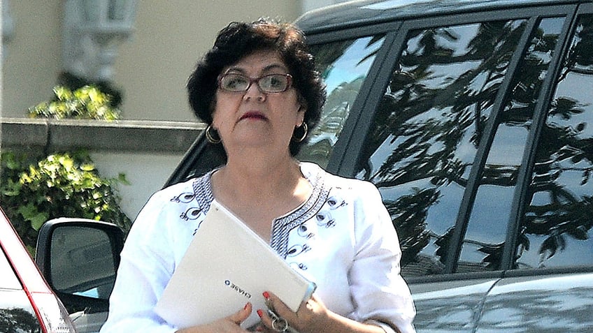 Teresa Reveles outside her car holding documents