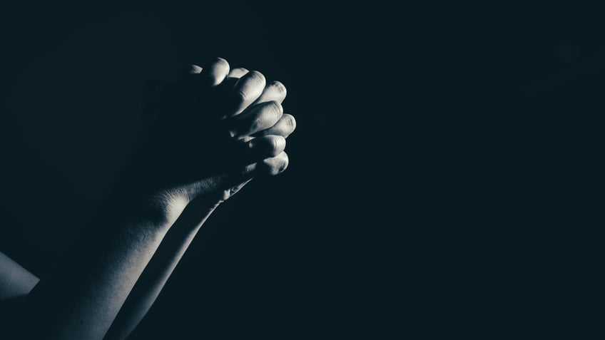 praying woman hand in the dark ( praying in secret room concept )in white tone