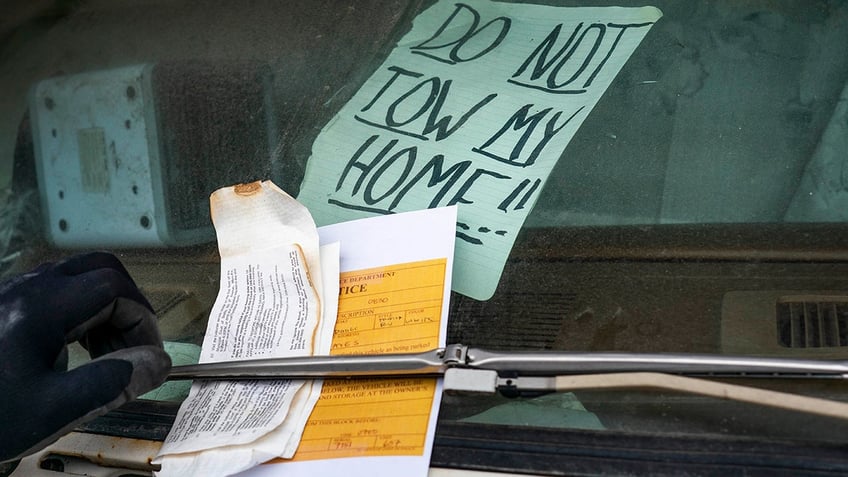 Sign reading "Do not tow my home" on windshield of RV