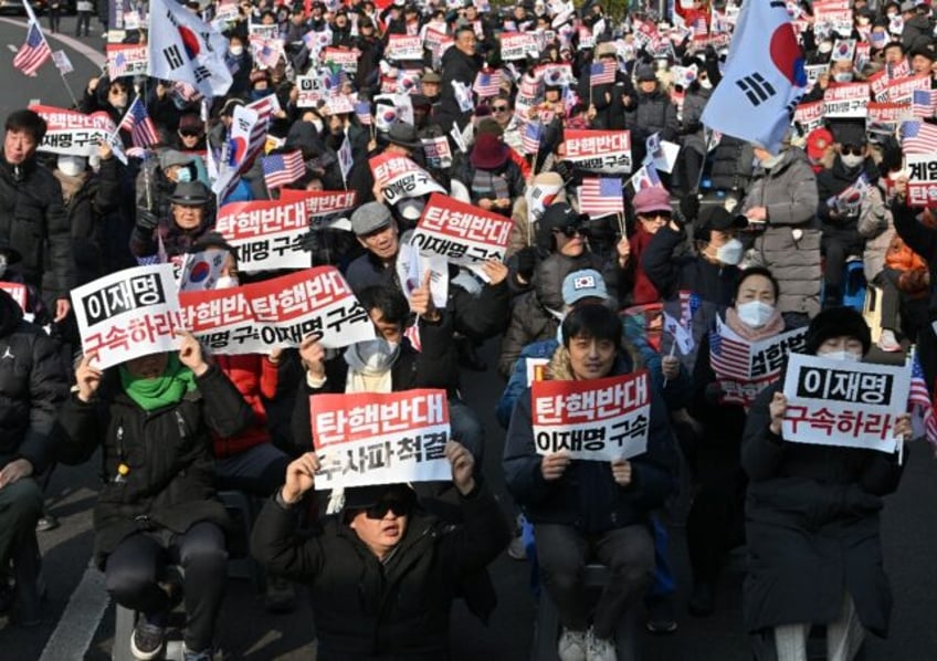 Supporters of impeached South Korea President Yoon Suk Yeol hold up anti-impeachment placa