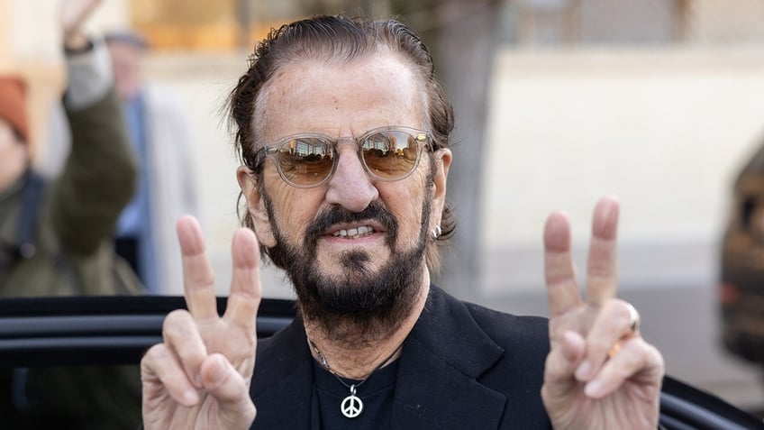 Close up of Ringo Starr flashing peace signs