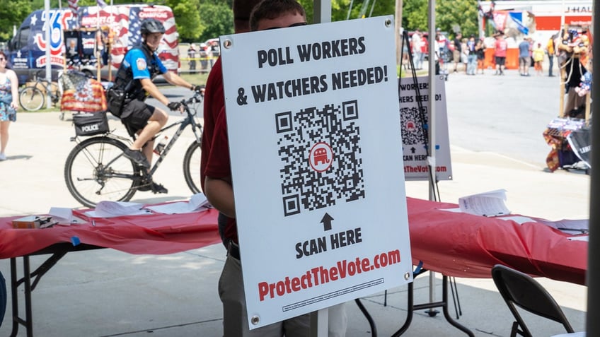 A booth for registering poll workers stands near where people line up to see Republican presidential nominee, former U.S. President Donald Trump speak on July 31, 2024, in Harrisburg, Pennsylvania.