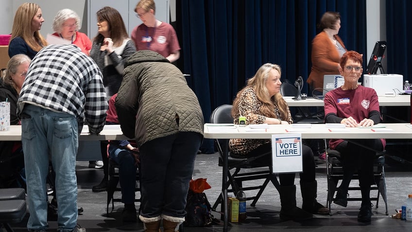 Poll workers help voters at an early voting site on February 17, 2024. in Battle Creek, Michigan. (Photo by Scott Olson/Getty Images)