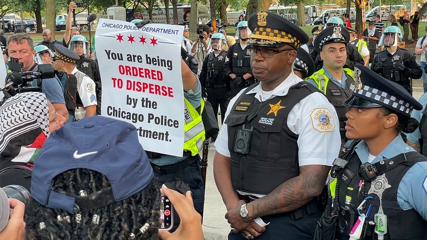 Chicago police holding up an "ordered to disperse" sign to anti-Israel agitators