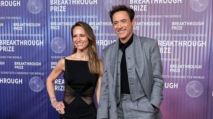 Susan Downey and Robert Downey Jr holding hands on the red carpet