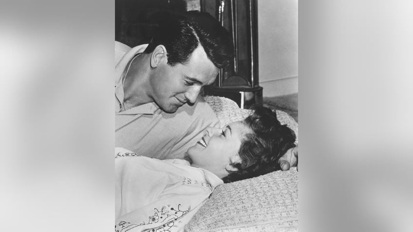 Rock Hudson looking at his wife Phyllis Gates in bed