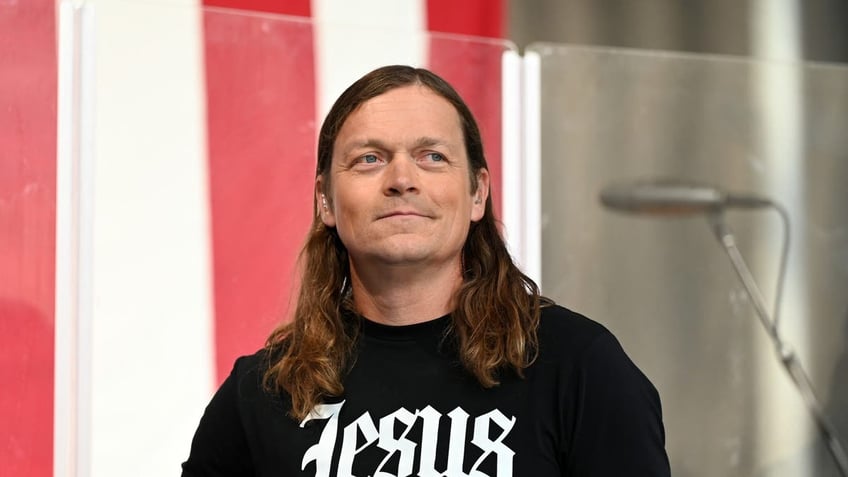 Brad Arnold of band Three Doors Down smiling with Jesus shirt