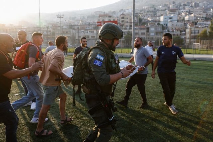 Israeli paramedics carry away the wounded for treatment after a rocket fired from Lebanon