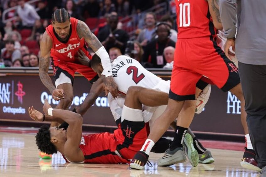 Jalen Green and Amen Thompson of the Houston Rockets fight with Terry Rozier of the Miami