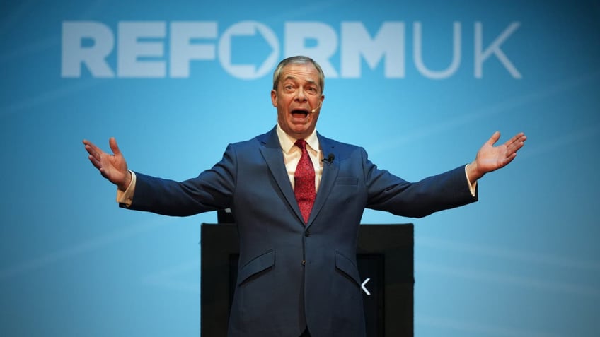 Nigel Farage speaking in front of Reform UK sign