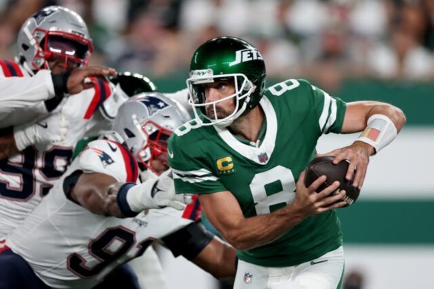 New York Jets quarterback Aaron Rodgers scrambles in an NFL victory over the New England P