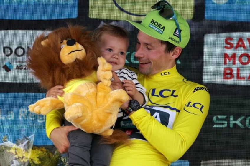 Primoz Roglic celebates his overall victory in the Criterium du Dauphine with his child on