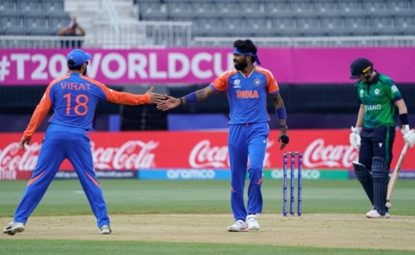 India's Hardik Pandya (C) celebrates with Virat Kohli (L) after taking a wicket in a T20 W