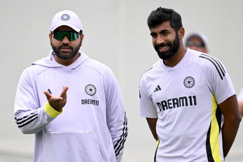 India's captain Rohit Sharma (L) chats with Jasprit Bumrah ahead of the Sydney Test