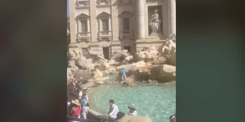 rome tourist stuns onlookers by climbing across historic landmark to fill water bottle