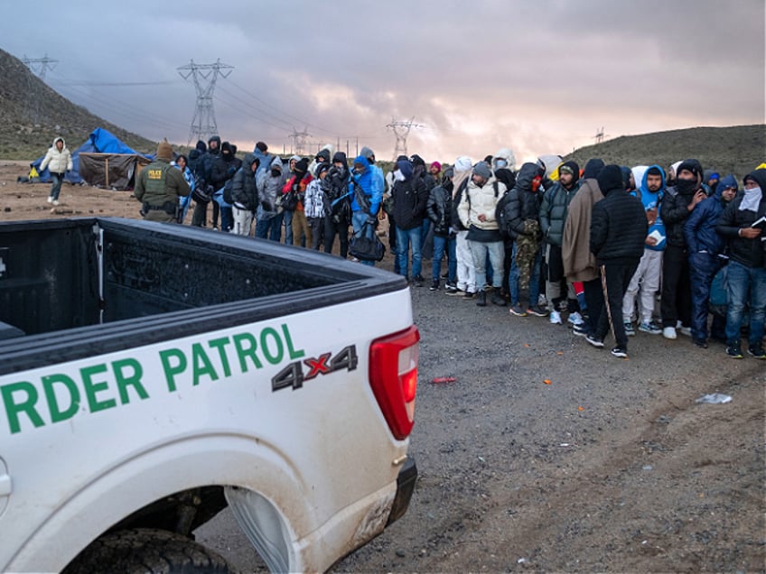 Asylum seekers wait in line to be processed by the Border Patrol at a makeshift camp near the US-Mexico border east of Jacumba, San Diego County, California, January 2, 2024. (Photo by Guillermo Arias / AFP) (Photo by GUILLERMO ARIAS/AFP via Getty Images)