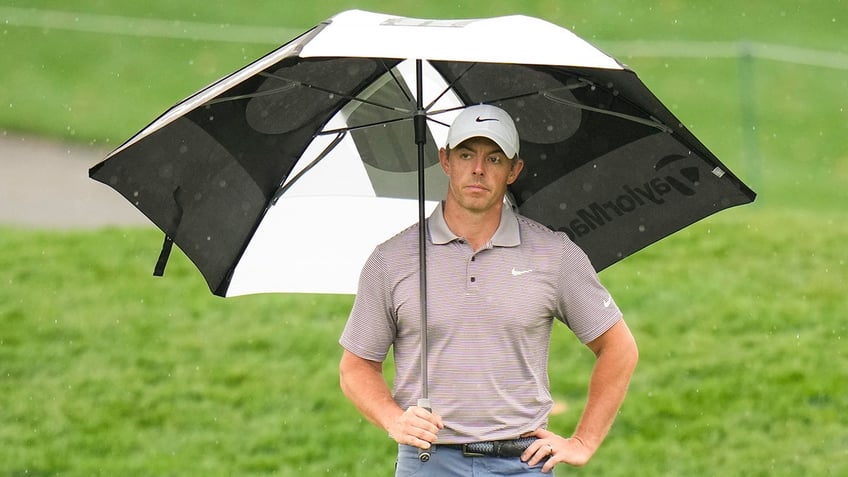 Rory McIlroy stands in rain