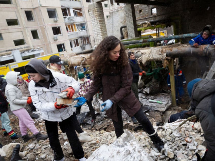 Residents are removing the rubble outside an apartment building in the Solomianskyi district, which was destroyed in the Russian missile attack on Tuesday, January 2, in Kyiv, Ukraine, on January 3, 2024. (Photo by Ukrinform/NurPhoto via Getty Images)