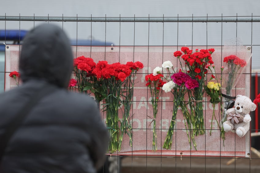 A person stands next to a makeshift memorial in front of the Crocus City Hall, a day after a gun attack in Krasnogorsk, outside Moscow, on March 23, 2024. Gunmen who opened fire at a Moscow concert hall killed more than 60 people and wounded over 100 while sparking an inferno, authorities said on March 23, 2024, with the Islamic State group claiming responsibility. (Photo by STRINGER / AFP) (Photo by STRINGER/AFP via Getty Images)