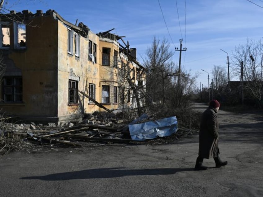 A local resident walks past a heavily damaged building in Kostyantynivka, near the front l