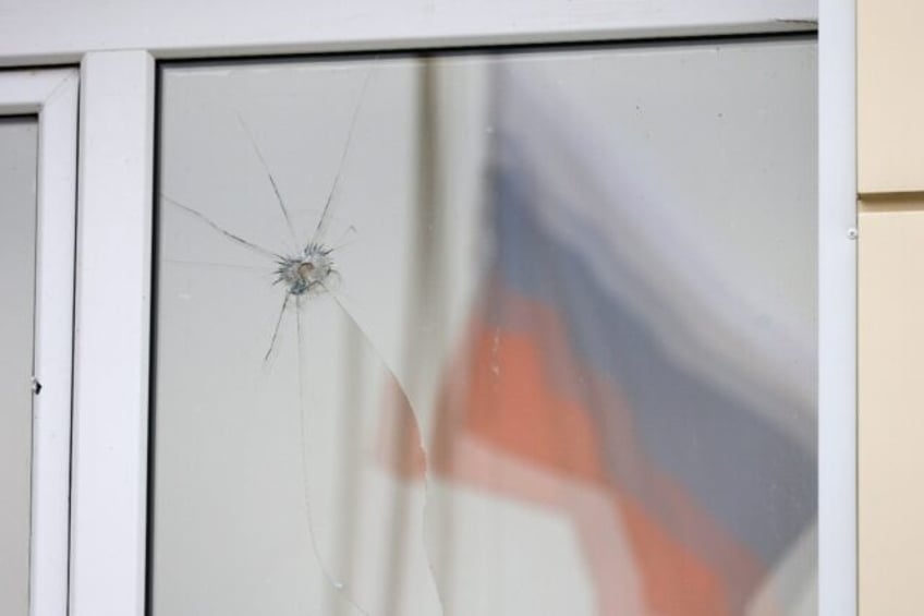 A Russian flag reflected in a damaged window after an aerial attack near Belgorod on Tuesd