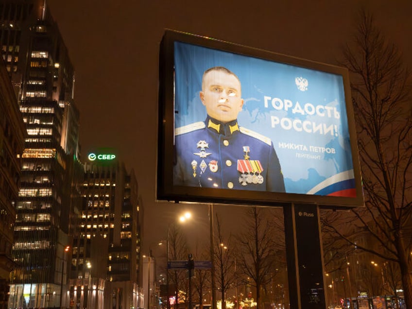 A pedestrian walks near a huge billboard with a portrait of a Russian officer Nikita Petro