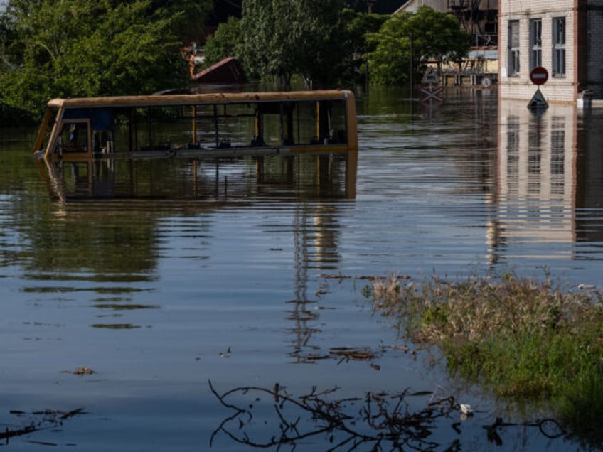 KHERSON, UKRAINE - JUNE 07: A burnt out public transport bus is submerged in water as water levels rise after the explosion at the Kakhovka hydropower plant unleashed floodwaters in Kherson, Ukraine on June 07, 2023. (Photo by Seth Herald/Anadolu Agency via Getty Images)