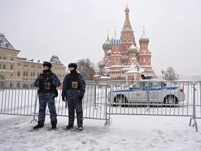 Police officers secure an area in front of Saint Basil's Cathedral on the snow-covered Red Square in Moscow on December 17, 2023. The height of snowdrifts in Moscow on December 17, 2023, reached 38 centimeters, breaking an 82-year-old record in the entire history of meteorological observations. (NATALIA KOLESNIKOVA/AFP via Getty)