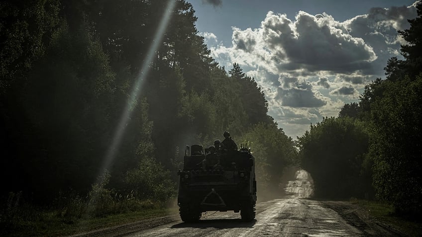 Ukrainian servicemen ride a military vehicle near the Russian border in Sumy region