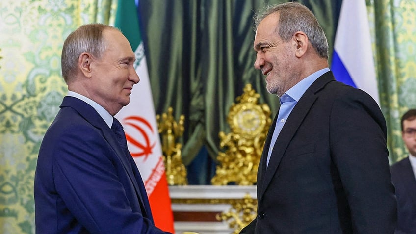 Russian President Vladimir Putin shakes hands with Iranian President Masoud Pezeshkian in Moscow