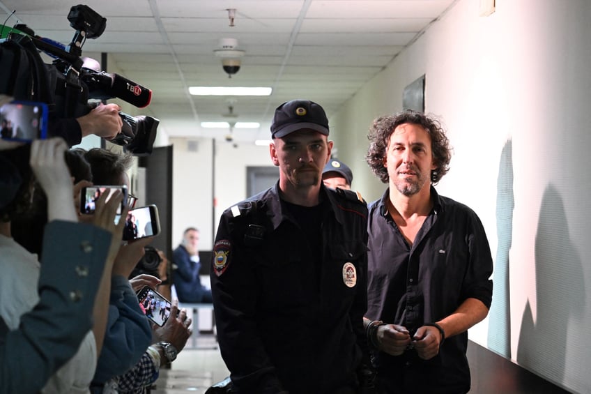 Laurent Vinatier (R), a French national who works with a Swiss-based conflict mediation non-profit organisation, is escorted by a Russian law enforcement officer prior to his pre-trial detention hearing in Moscow on June 7, 2024. Russian prosecutors on June 7, 2024 requested that a French man effectively accused of spying be sent to jail pending trial for breaching the country's "foreign agents" law, his lawyer told AFP. (Photo by NATALIA KOLESNIKOVA / AFP) (Photo by NATALIA KOLESNIKOVA/AFP via Getty Images)