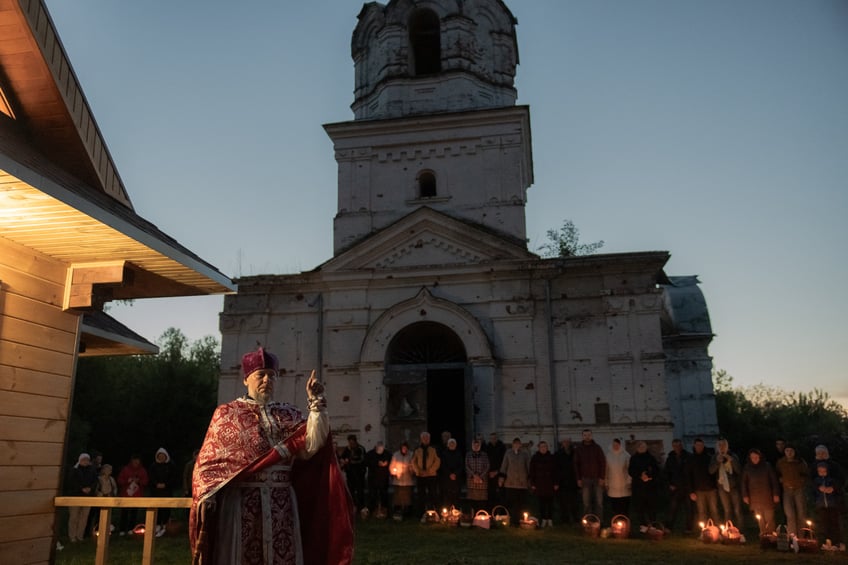 Ukrainian priest Serhii speaks to Orthodox devotees carrying baskets of traditional Easter delights on Orthodox Easter outside the Church of the Ascension that was destroyed during the Russian occupation in the spring of 2022, in the village of Lukashivka, Chernigiv region, on May 5, 2024, amid the Russian invasion of Ukraine. (Photo by Roman PILIPEY / AFP) (Photo by ROMAN PILIPEY/AFP via Getty Images)