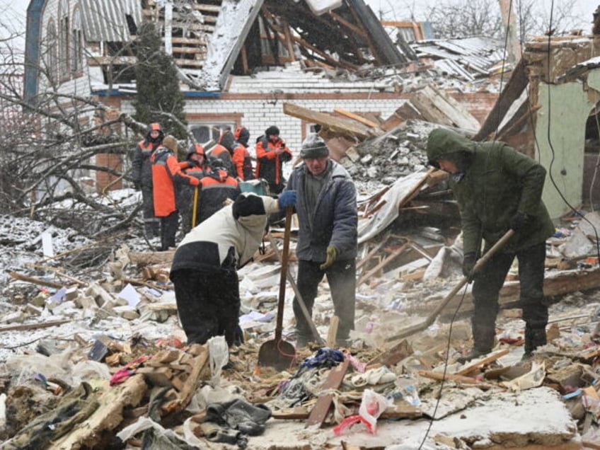 TOPSHOT - Rescuers and local residents clear debris following Russian strikes, in Zmiiv, Kharkiv region, on January 8, 2024, amid the Russian invasion of Ukraine. At least three people have been killed and dozens injured in a fresh wave of Russian strikes across Ukraine, regional officials said on January 8, …