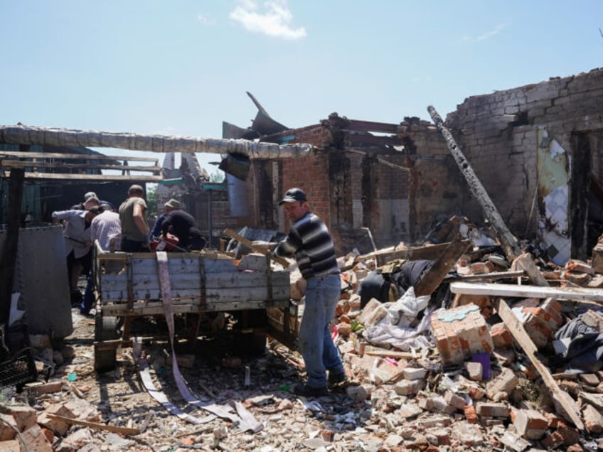 VELYKYI BOBRYK, UKRAINE - JUNE 24: Local residents clean up debris from the yard of house