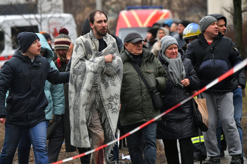 TOPSHOT - Local residents react outside a building, damaged as a result of missile attack in Kyiv on February 7, 2024, amid the Russian invasion of Ukraine. At least three people were killed in a "massive" wave of Russian missile and drone attacks across Ukraine early on February 7, 2024, President Volodymyr Zelensky said. (Photo by Sergei SUPINSKY / AFP) (Photo by SERGEI SUPINSKY/AFP via Getty Images)