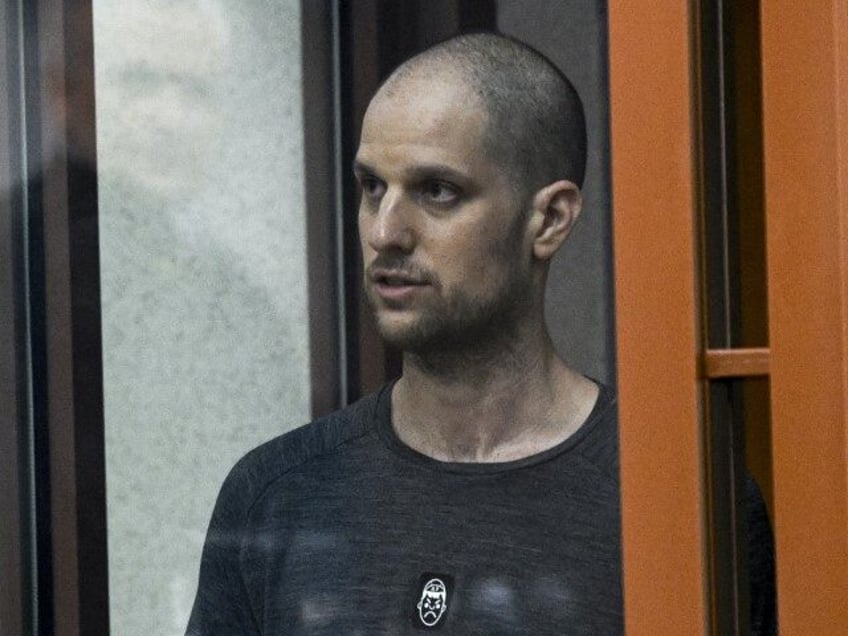 Wall Street Journal reporter Evan Gershkovich stands listening to the verdict in a glass c