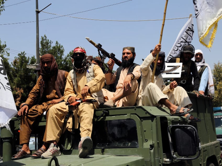 Taliban fighters celebrate the third anniversary of the withdrawal of US-led troops from A