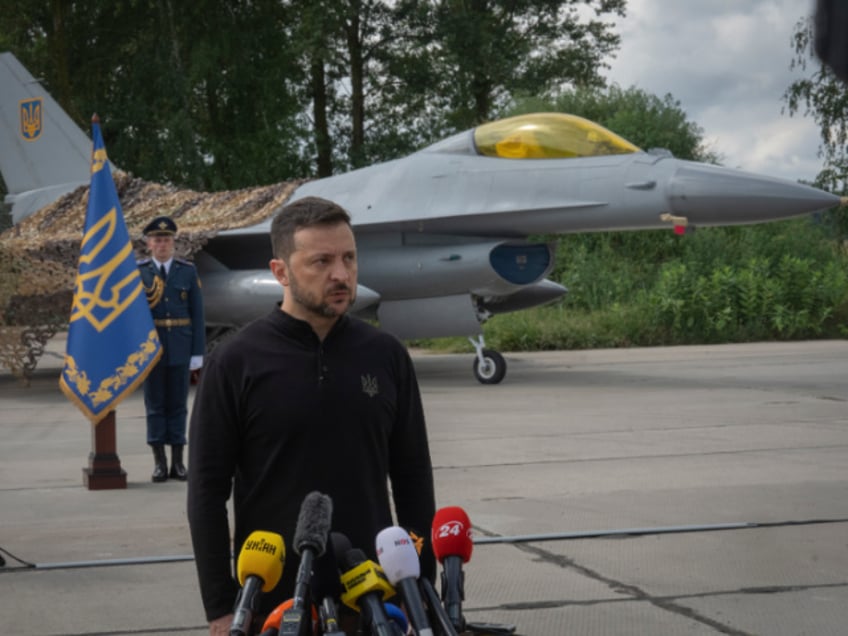 Ukraine's President Volodymyr Zelenskyy answers media questions standing against the background of Ukraine's Air Force's F-16 fighter jets in an undisclosed location in Ukraine, Sunday, Aug. 4, 2024. The F-16 fighter jets that have been delivered to Ukraine by Western countries will be flying sorties in Ukrainian skies and helping the country's current fleet of Soviet-era jets to counter Russia's invasion. (AP Photo/Efrem Lukatsky)