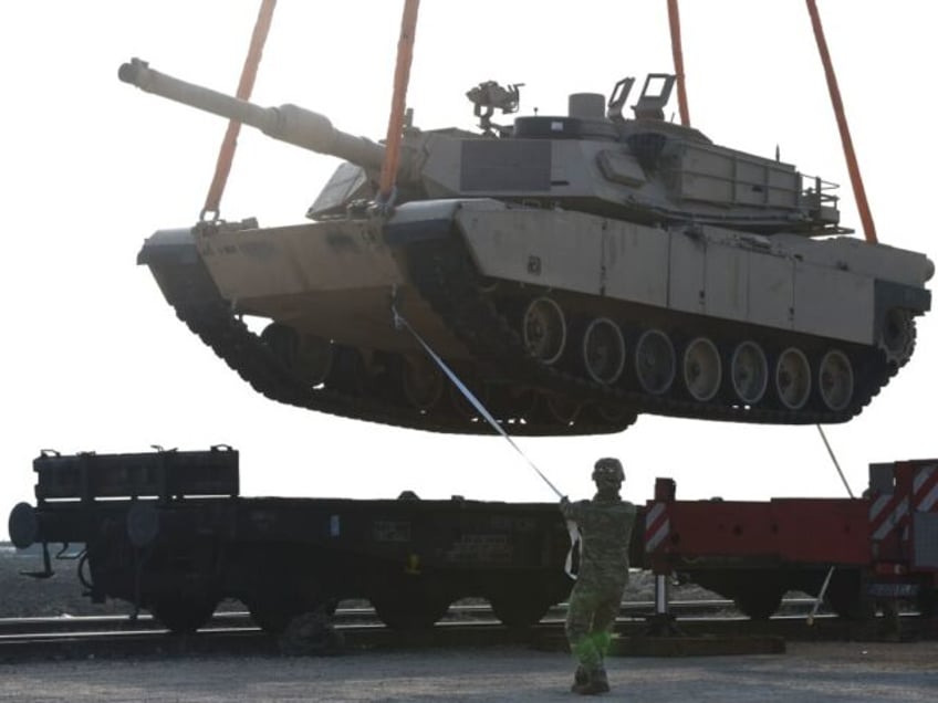 A US soldier helps to manoever a tank from a railway car as US Army personnel offload military equipment at the Mihail Kogalniceanu Air Base near Constanta in Romania on February 14, 2017. Soldiers and equipment from the 3rd Armored Brigade Combat Team, 4th Infantry Division, arrived at the Mihail …