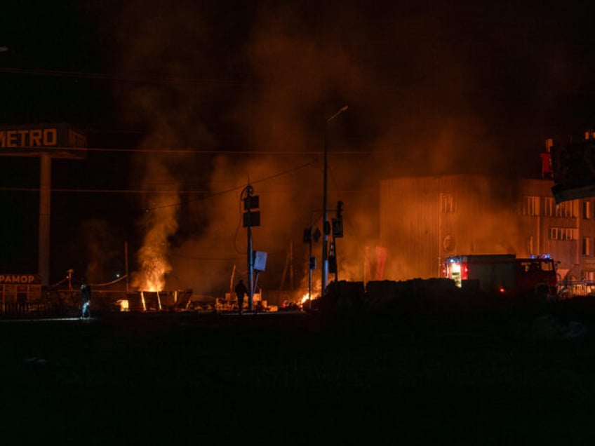 Rescue workers extinguish the fire at the site of a Russian drone attack in Kharkiv, Ukrai