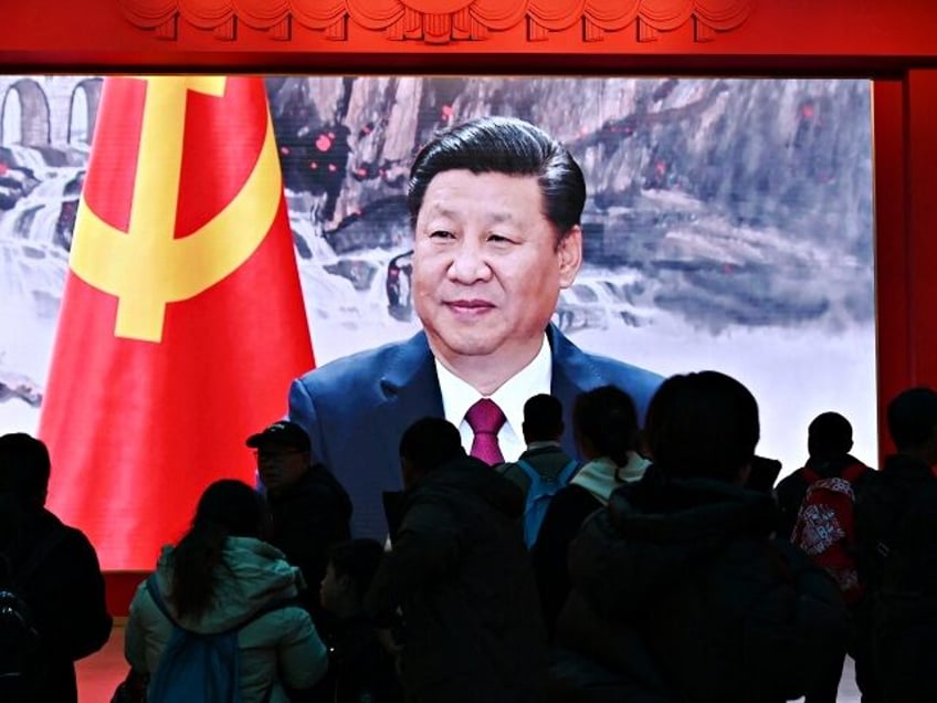 People watch a video featuring Chinese President Xi Jinping at the Military Museum in Beij