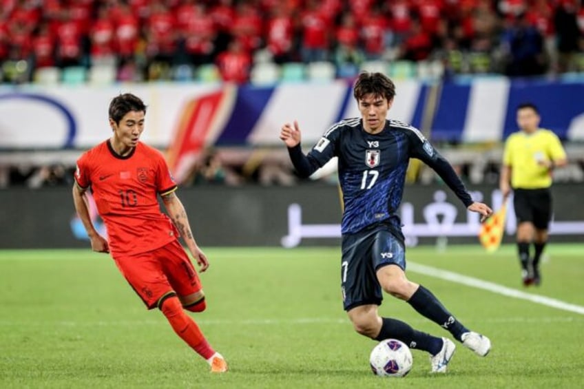 China's Wei Shihao (L) fights for the ball with Japan's Ao Tanaka