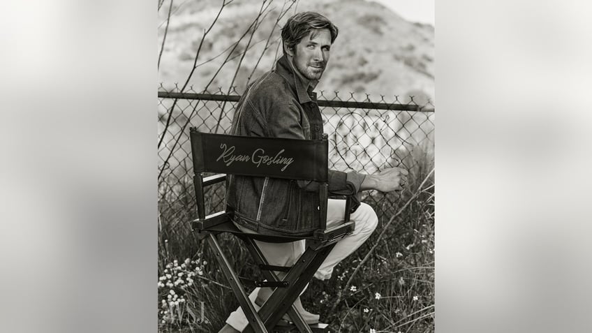 Ryan Gosling sitting in a chair with his name on it