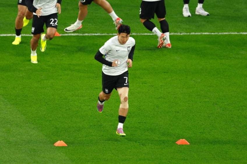 Captain Son Heung-min, his fingers bandaged, warms up ahead of South Korea's semifinal los