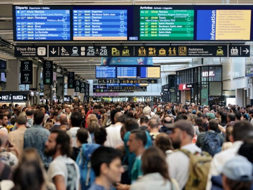 Passengers gather around the departure and arrival boards at the Gare Montparnasse train s